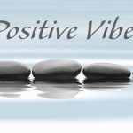 pebble on water with the words positive vibes