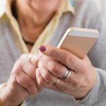 Older woman tapping on cell phone