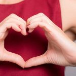 woman making heart sign.